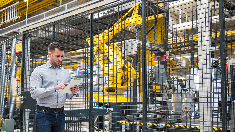 A man in a factory, using a tablet
