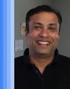 Man in dark shirt smiles at camera