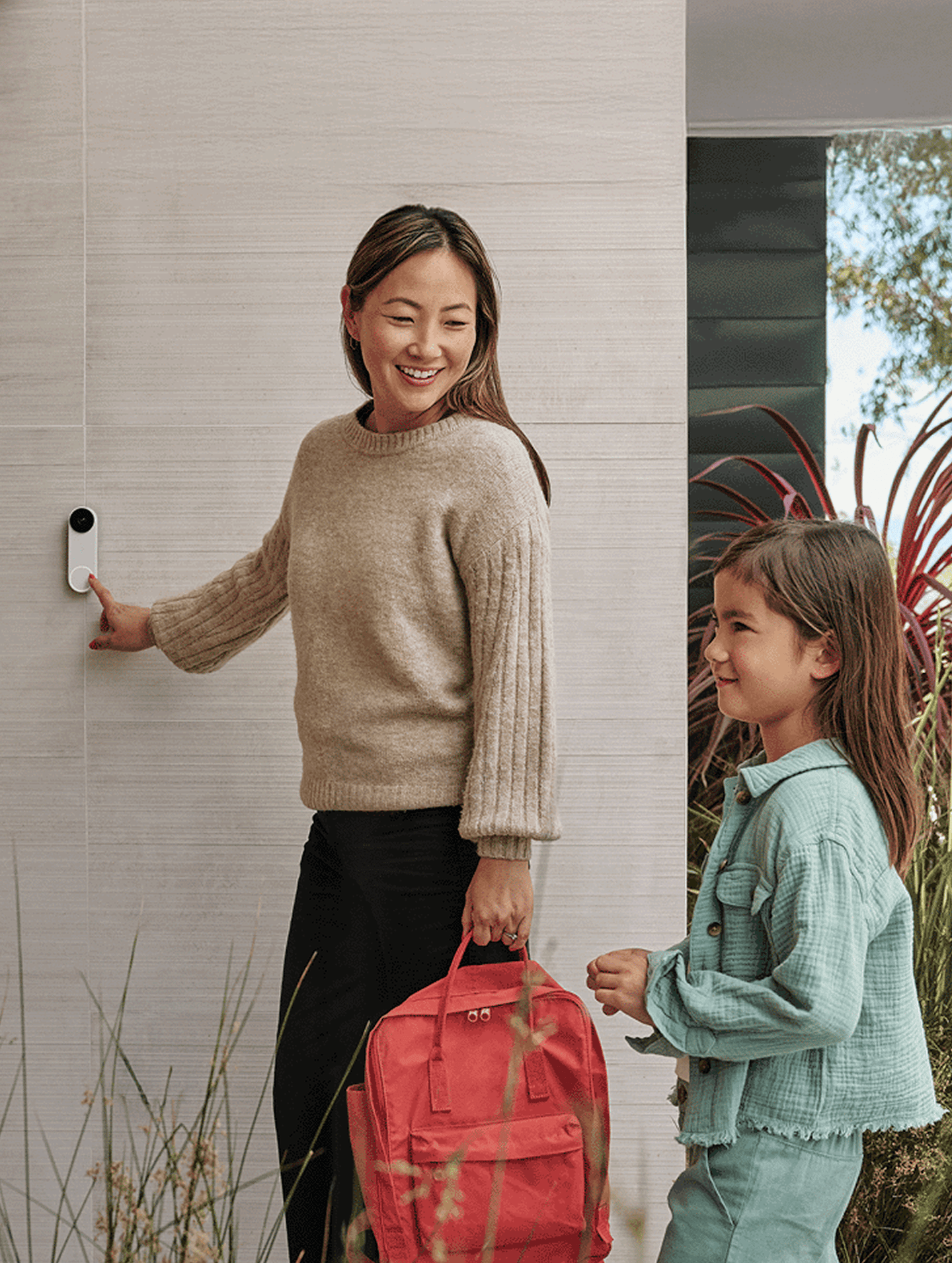 Image of woman and child pushing the nest doorbell button