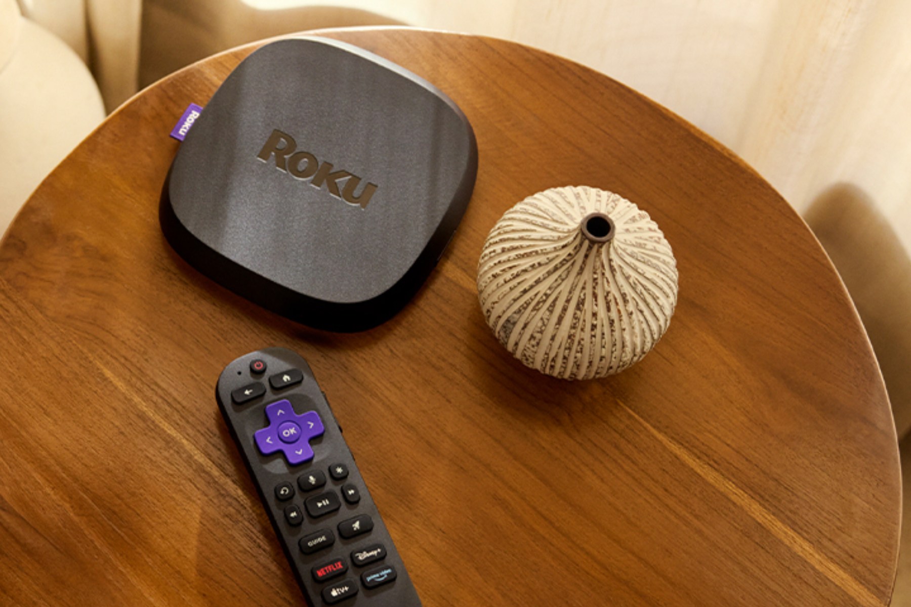 Roku's Ultra streaming box and remote on top of a table.